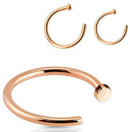 Three rose gold-tone nose hoops with flat disc ends, one shown up close
