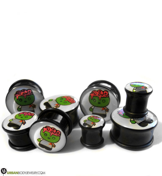 Black plugs in several sizes, each printed with a cartoon green zombie with an exposed pink brain