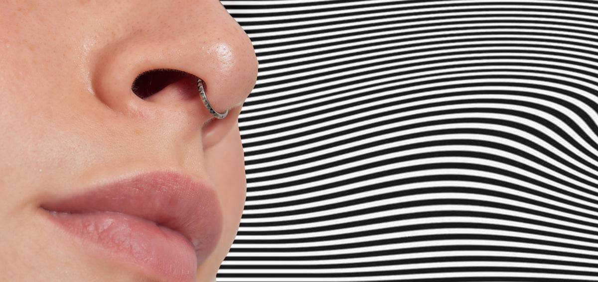 Close-up of a nose in profile with a textured silver-tone septum ring
