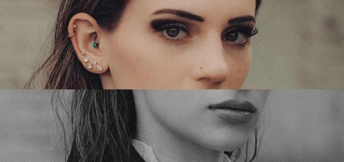 Woman's ear with a helix stud and hoop, a turquoise daith ring and stacked crystal studs in the lobe