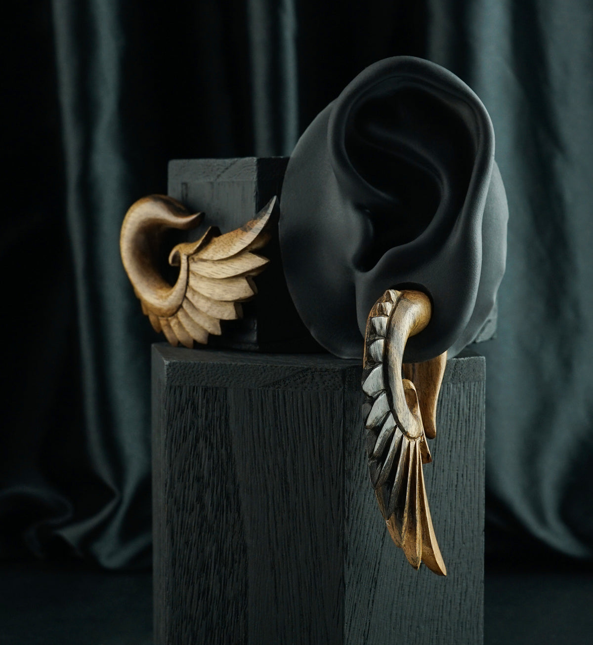 Areng Wood Angel Wing Hanger Plugs, shown in the lobe of a black display ear