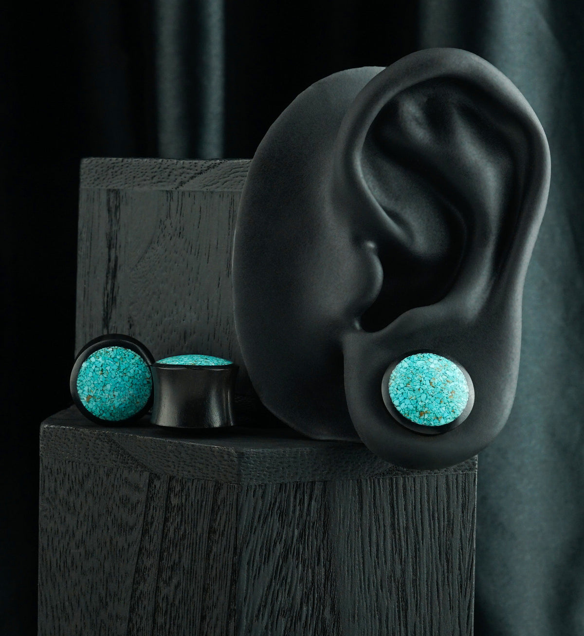 Areng Wood Plugs With Turquoise Stone Inlay, shown in the lobe of a black display ear