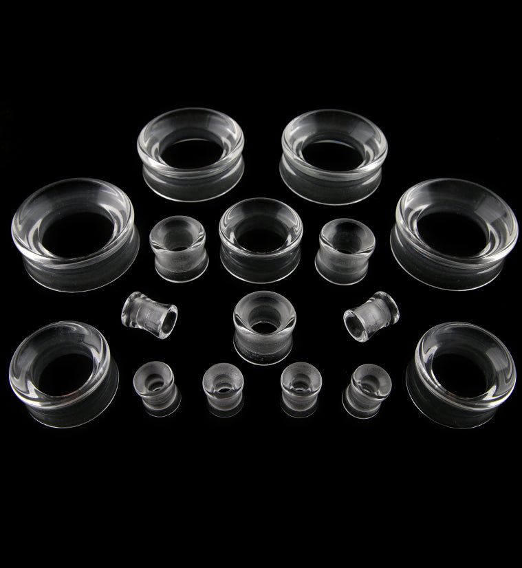 Clear Glass Tunnel Plugs, full range of sizes on a black background