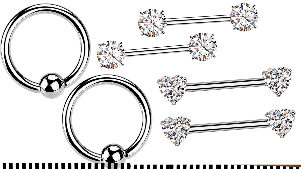 Two silver-tone captive bead rings beside four nipple barbells, two with round crystal ends and two with heart ends